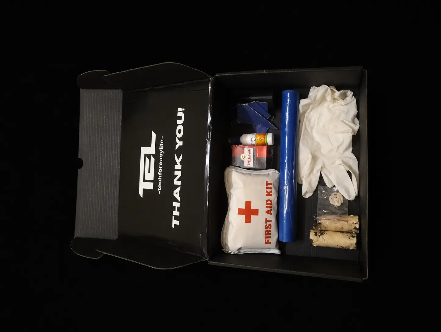 Open TEL educational kit on a matte-black studio background