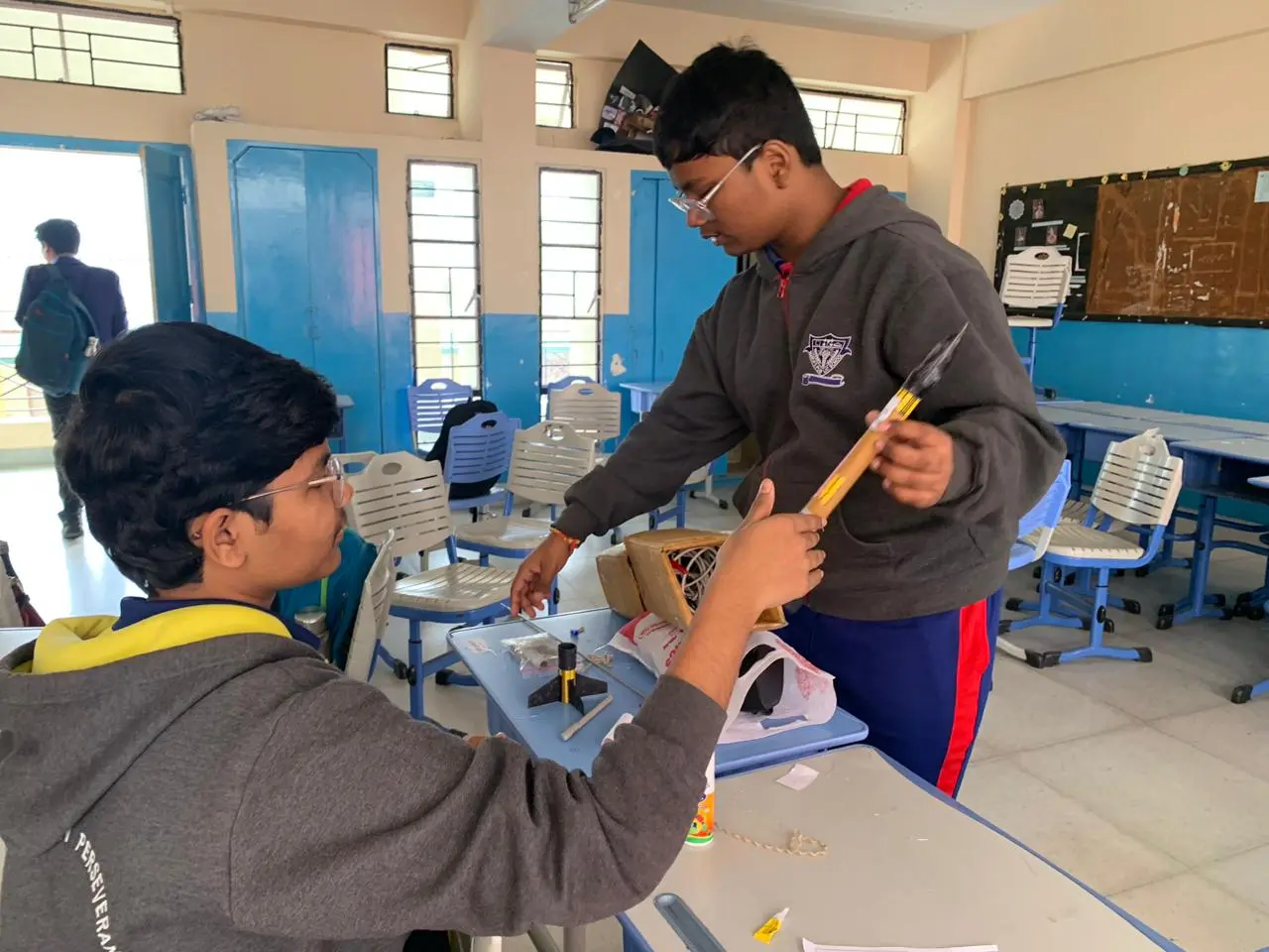 Students examining a TEL rocket prototype in a classroom